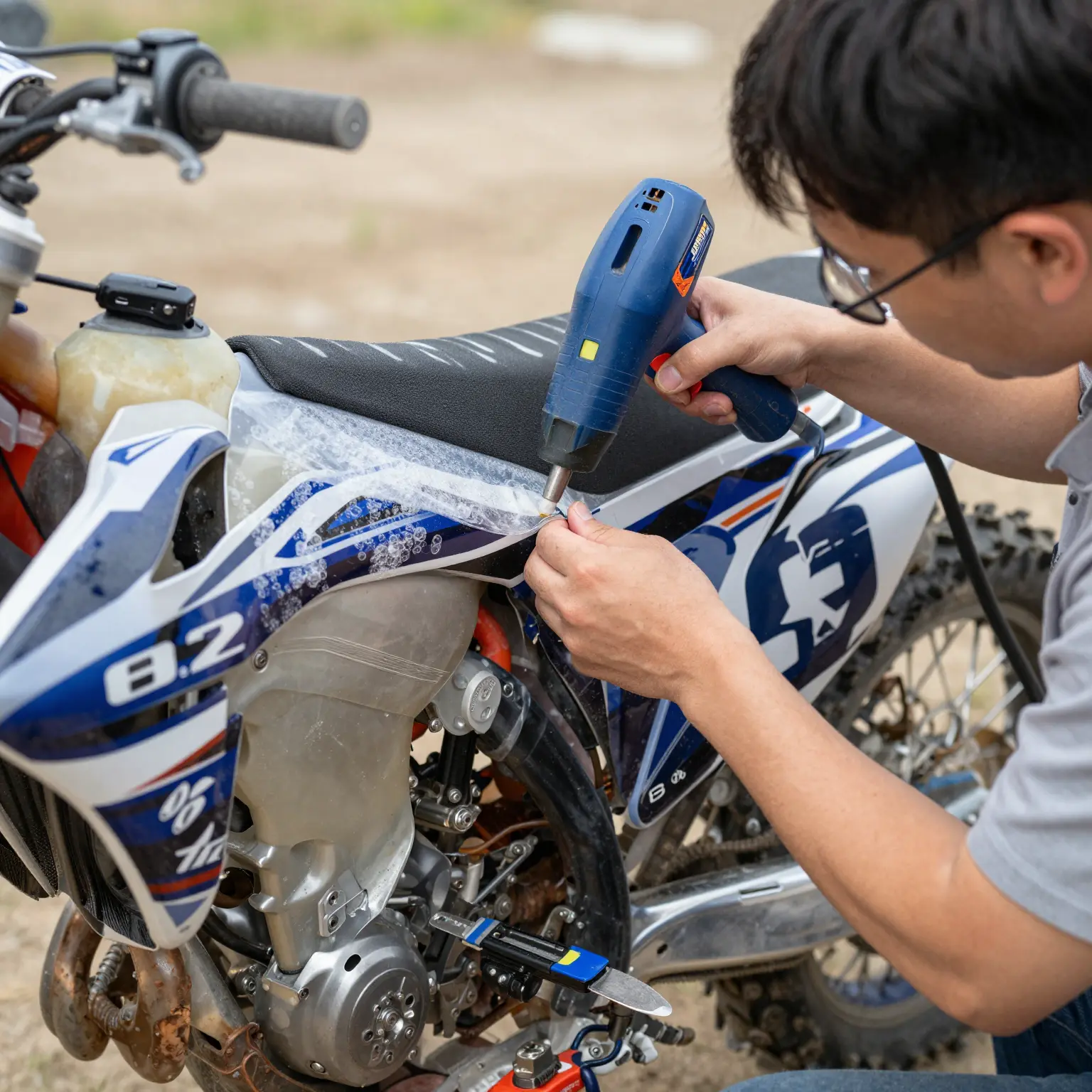 Professional graphic installer applying dirt bike graphics
